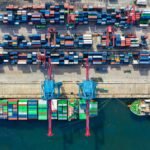 Drone shot capturing vibrant container ships and dock in North Jakarta port, Indonesia.