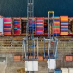 Aerial view of colorful cargo containers at a bustling port in Jakarta, Indonesia.